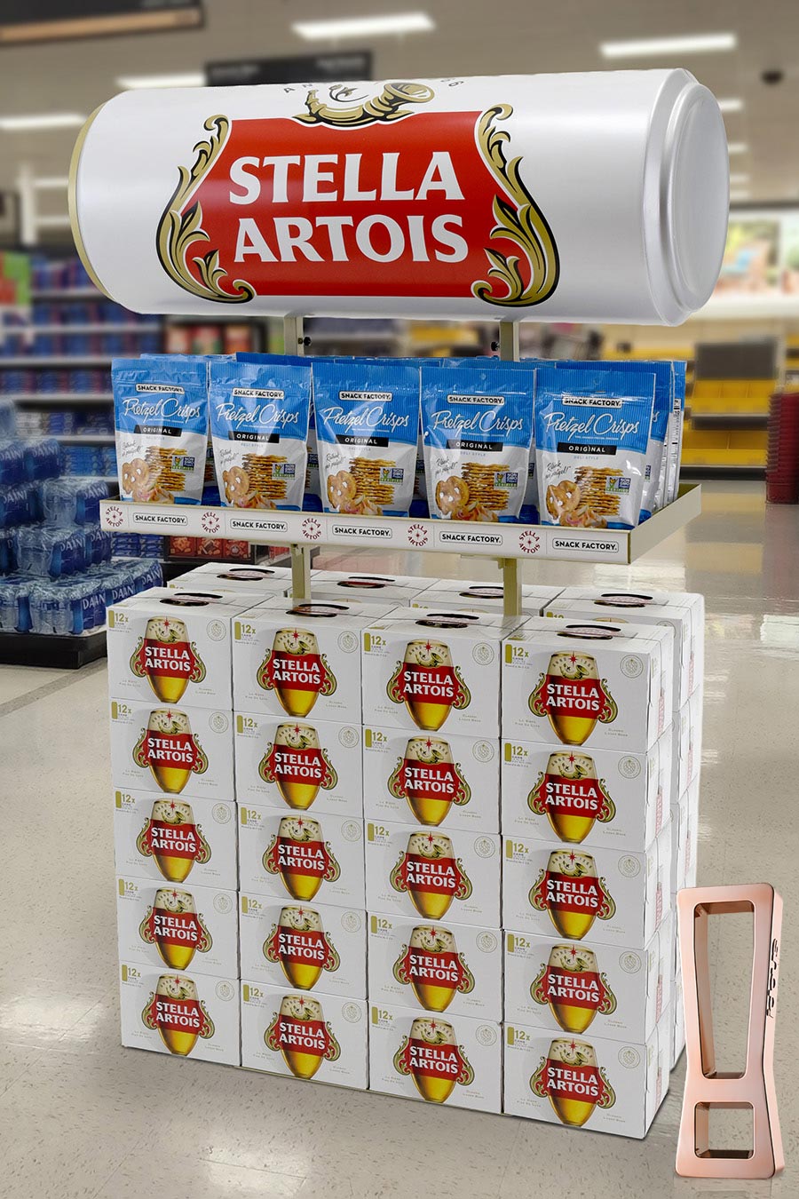 Promotional Stella Artois beer display with a large sign and stacked 12-pack boxes in a store aisle, branded red and gold.